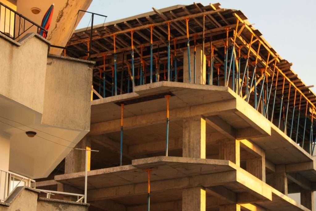 Multi-storey concrete frame building under construction with scaffolding