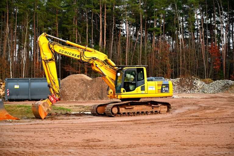 Excavator digging into brown soil on a construction site